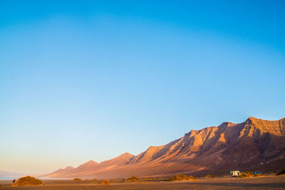 Scenic view of mountains against clear blue sky