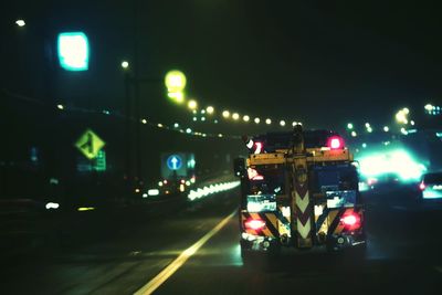 Cars on illuminated street at night