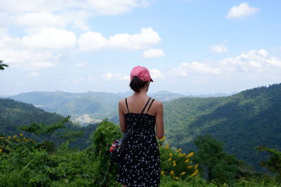 Woman standing on mountain against sky