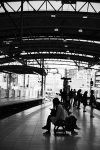 Woman sitting on railroad station platform