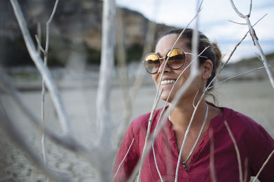 Portrait of a woman wearing sunglasses and smiling at sunset.