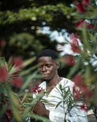 Portrait of smiling young man holding flowers