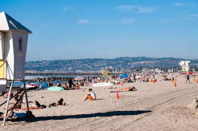 People at beach against sky