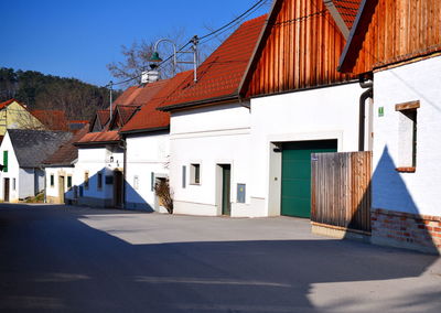 Houses by road against sky in city