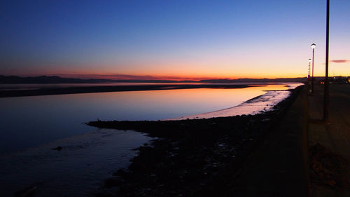 Scenic view of lake against clear sky during sunset