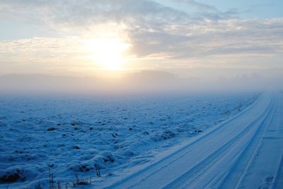 Scenic view of snow landscape against sky during sunset