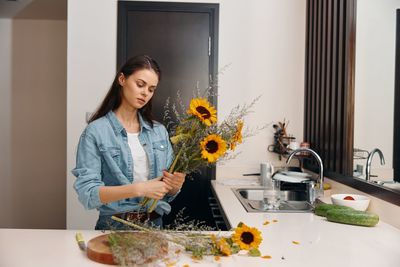 Portrait of young woman holding food at home