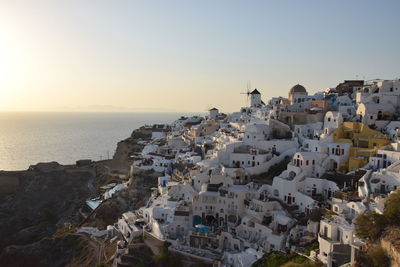 High angle view of townscape by sea against clear sky