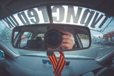 Portrait of man photographing car