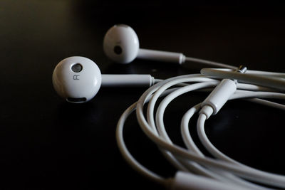 Close-up of earphones over black background
