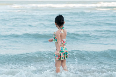 Rear view of boy standing on beach