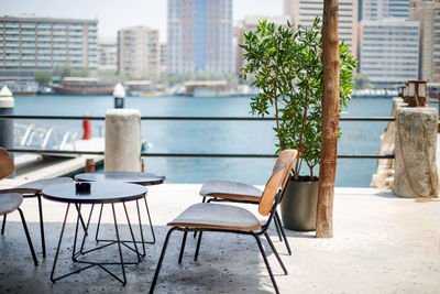 An outdoor cafe overlooking the dubai creek water canal with the deira district in the background