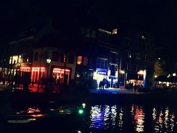 Illuminated buildings by street at night