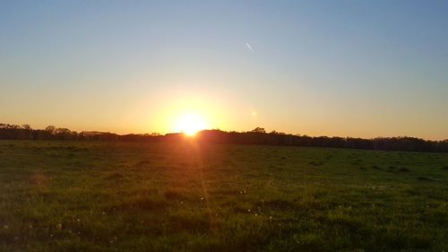 Scenic view of field against sky during sunset