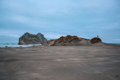 Scenic view of rocks on beach against sky