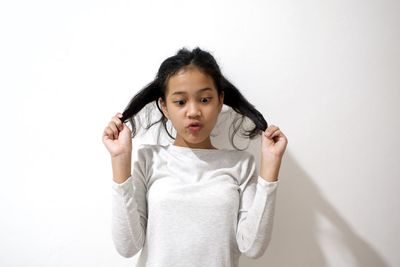 Portrait of girl standing against white background