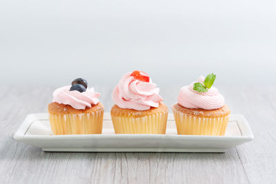 Close-up of cupcakes on table against white background