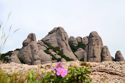 Low angle view of rock formation on mountain against clear sky