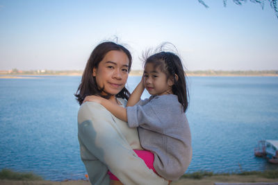 Portrait of a smiling girl on shore against sea