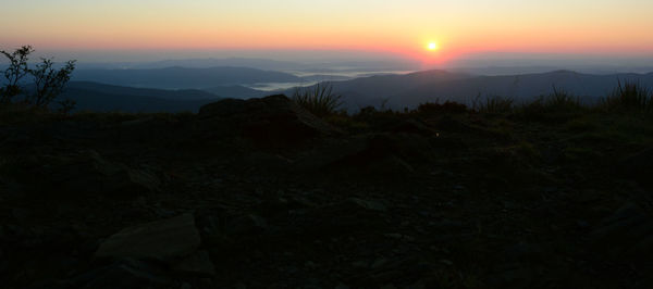 Scenic view of silhouette mountains against sky at sunset