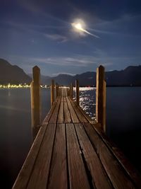 Pier over lake against sky during sunset