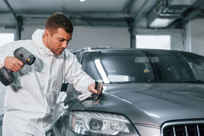 Professional worker. man in uniform is in the auto service.