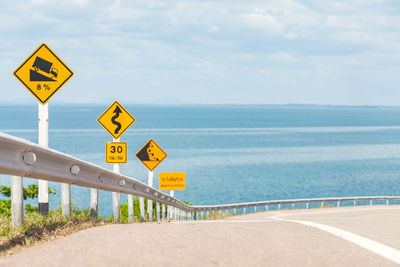 Signboards on road against sea