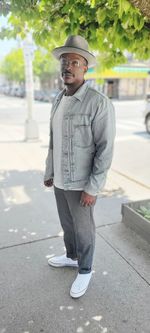 Portrait of young man standing on footpath