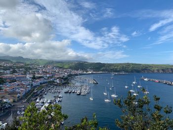 High angle view of sailboats in city by sea against sky