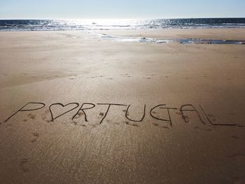 Text on beach against sky