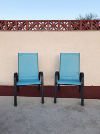 Deck chairs against clear blue sky