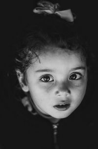 Close-up portrait of cute girl in dark