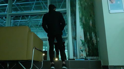 Rear view of silhouette man standing on staircase