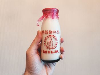 Close-up of cropped hand holding text on wall