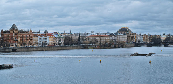 Buildings by sea against sky in city