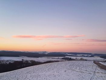 Scenic view of snow covered landscape against sky during sunset