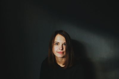 Portrait of young woman sitting in darkroom at home