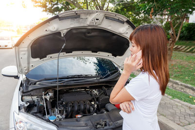 Full length of woman standing in car