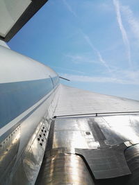 Low angle view of airplane wing against sky