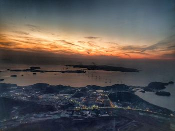 High angle view of townscape by sea against sky during sunset