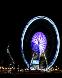 Low angle view of illuminated ferris wheel at night