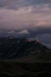 Scenic view of mountains against cloudy sky during sunset