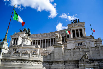 Low angle view of statues against sky in city