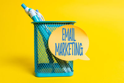 Close-up of information sign against yellow background