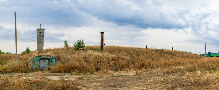 Abandoned factory on field against sky