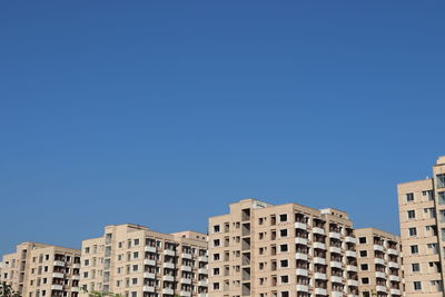 Low angle view of buildings against clear blue sky