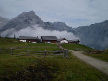 Built structure on field by mountain against sky