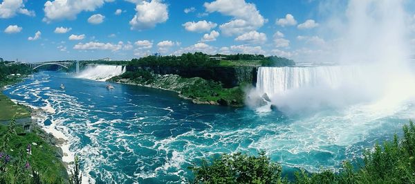 Scenic view of waterfall against sky at forest