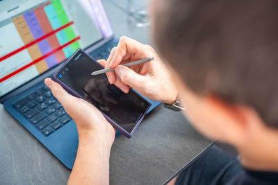 Cropped hands of woman using laptop