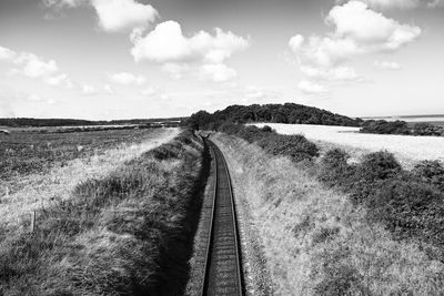 Railroad tracks on landscape against sky